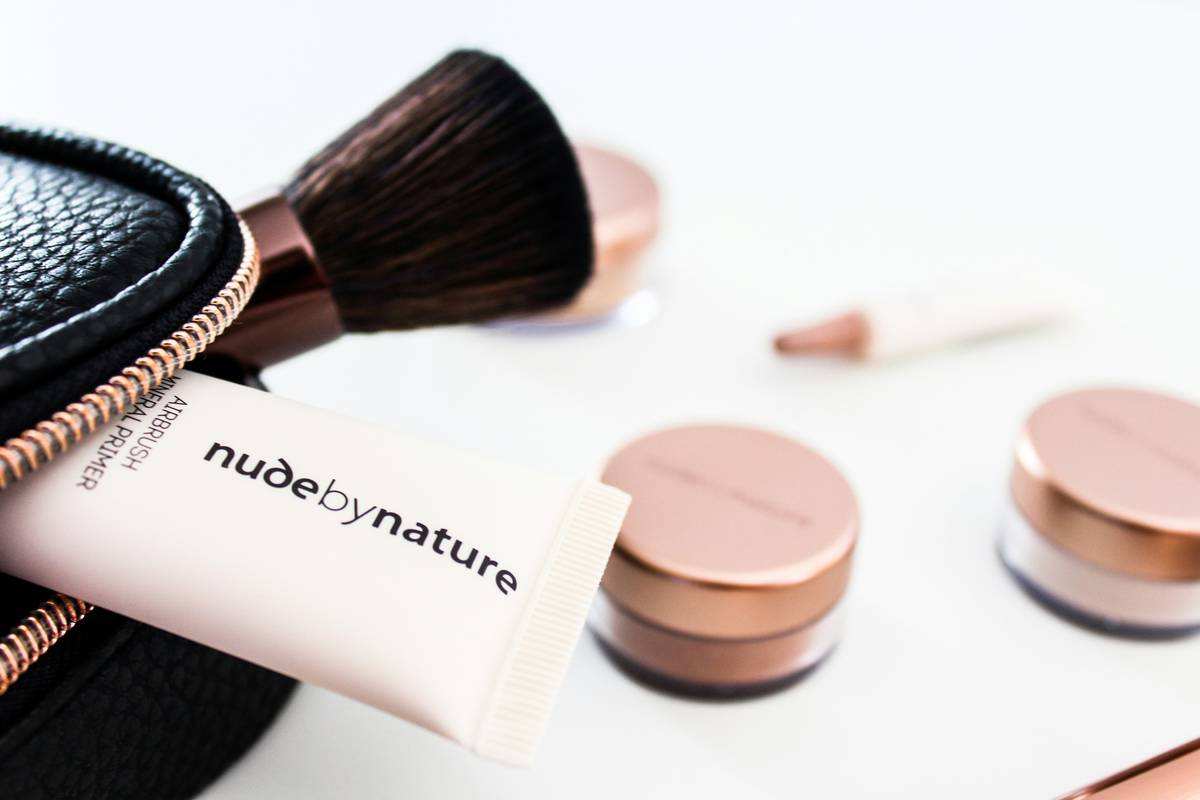 Woman applying clean and safe makeup with ingredient checklist visible