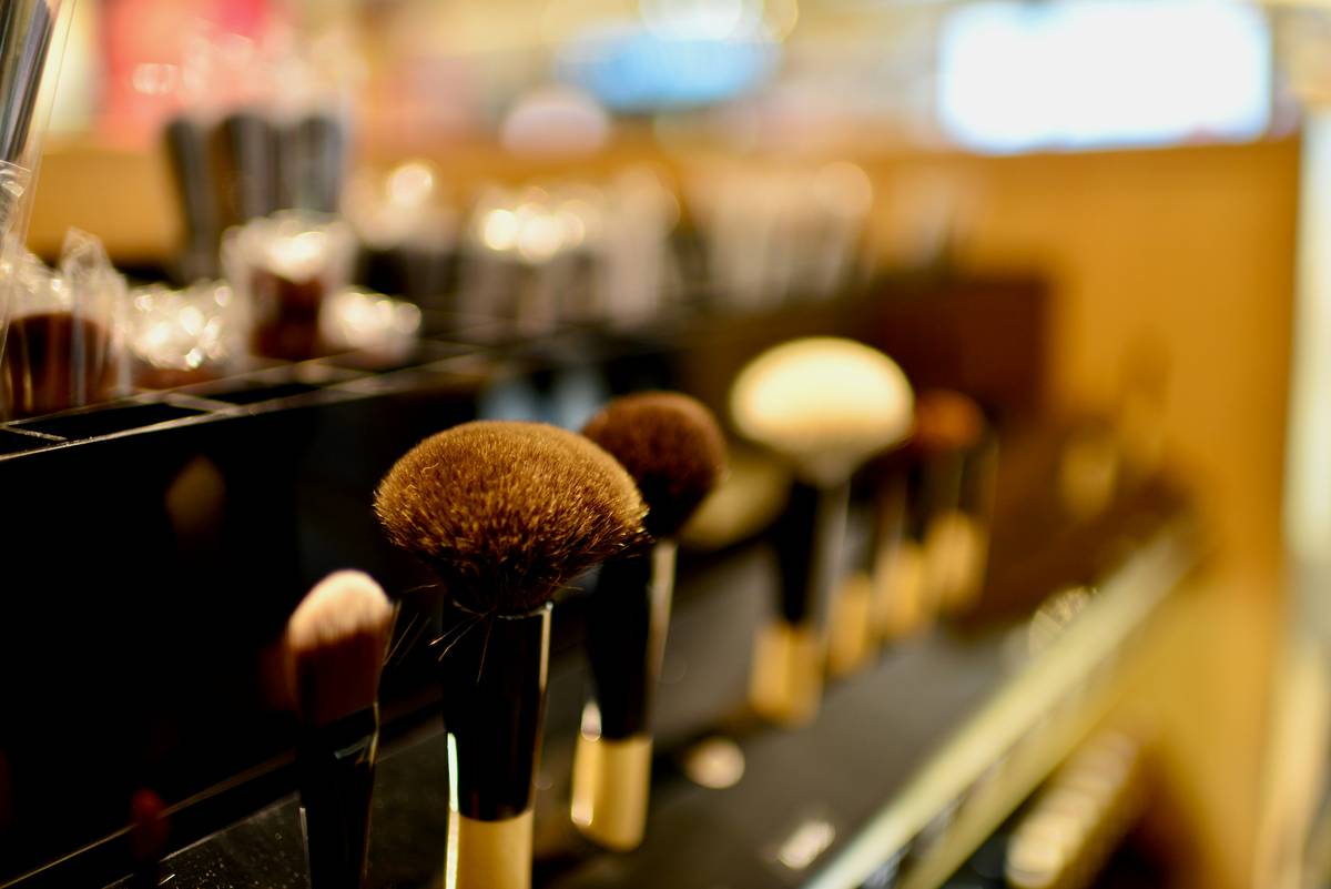 how to clean makeup: close-up of sanitized makeup brushes and compacts on a clean white surface